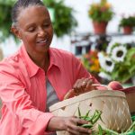 african american woman shopping for fresh vegetables at farmers market