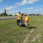 alumni working together to clean up highway litter