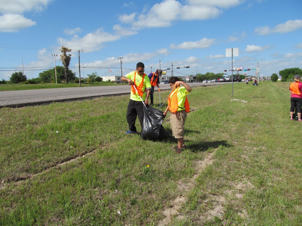 alumni working together to clean up highway litter
