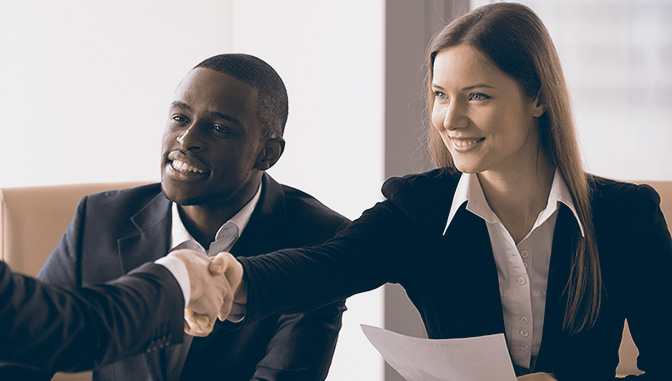 women and african american man in suits shaking hands