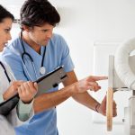female doctor and male nurse reading results on medical equiptment