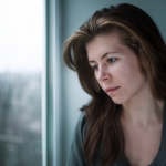 mujer deprimida con la mirada perdida en la ventana