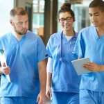 young nurses walking and looking at ipad