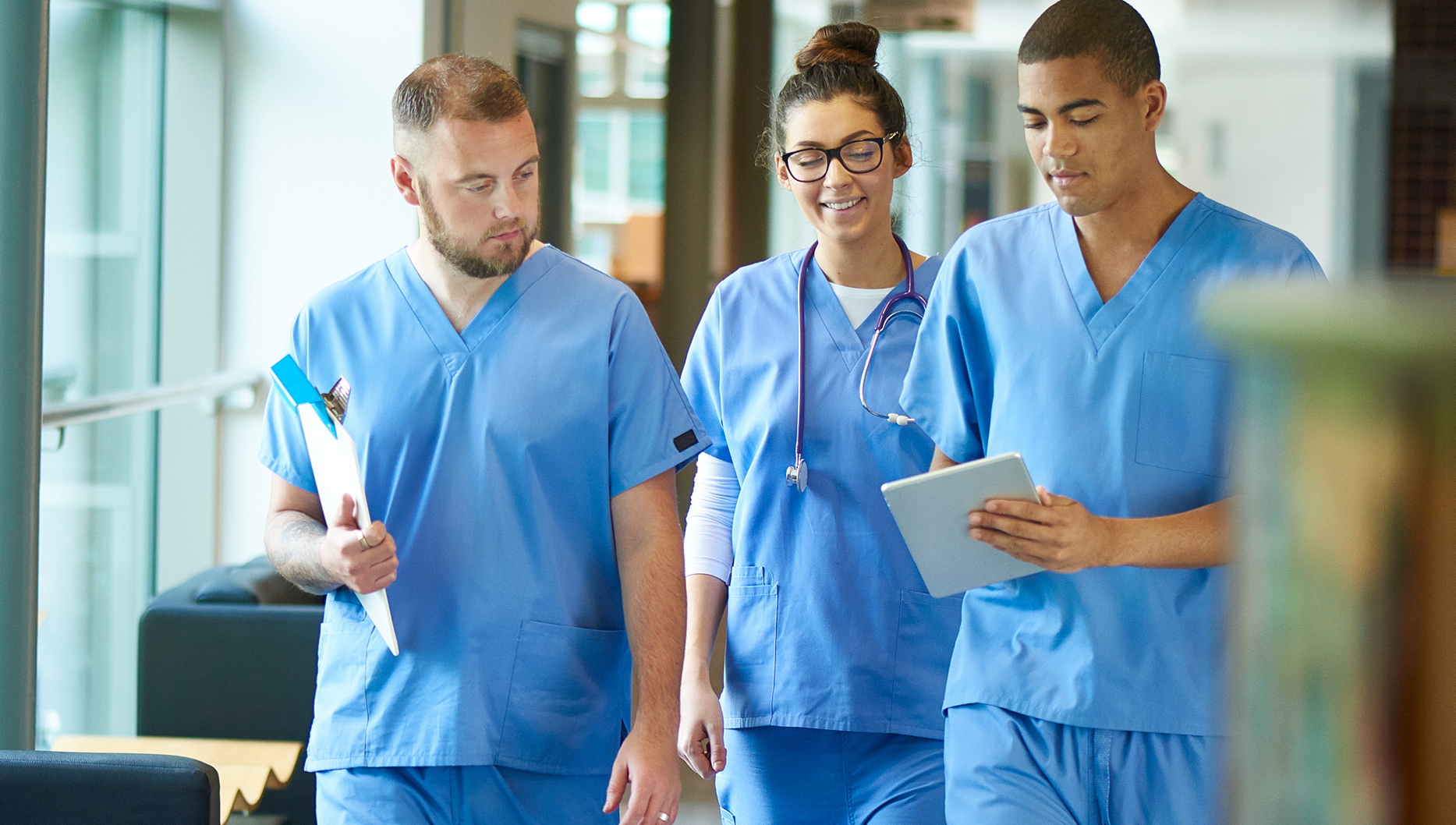 young nurses walking and looking at ipad