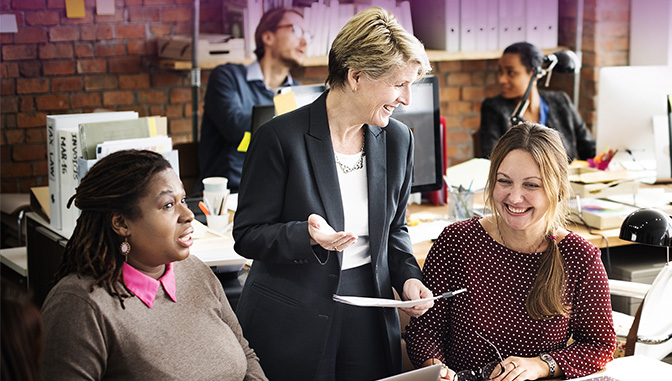 three professional women laughing