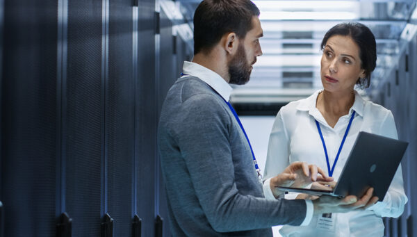 two cybersecurity professionals in a server room