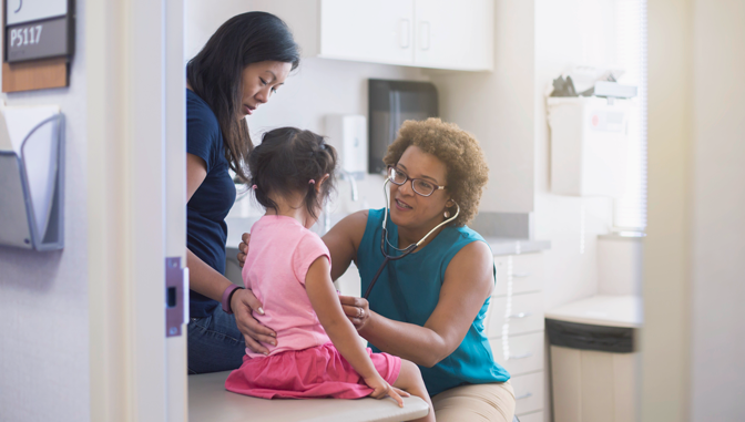 african american nurse doing a check up on a young asian girl and her mother