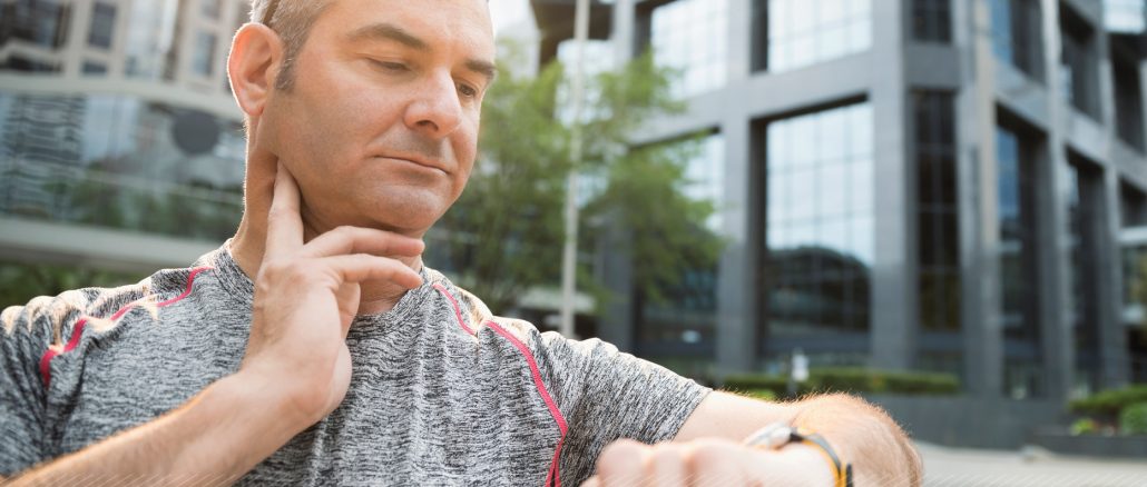 middle aged man checking pulse