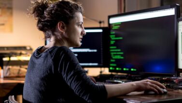 woman looking at code on a computer