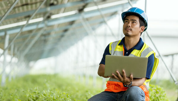 Tech Manager reviewing data in a greenhouse