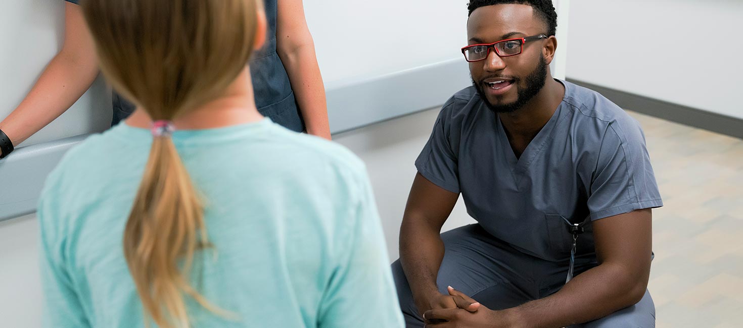Un estudiante de enfermería masculino participa en una discusión con otros estudiantes de la Universidad de Excelsior