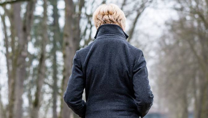 Woman with back turned in winter, suffering from Seasonal Affective Disorder