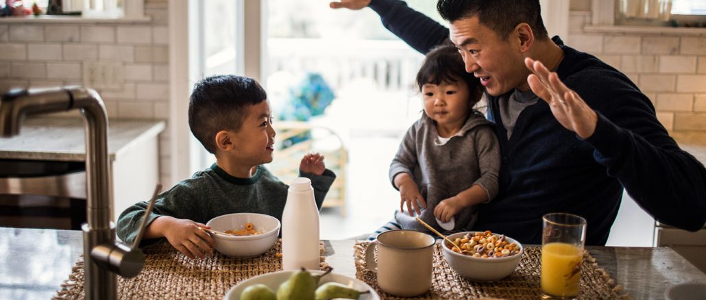 asian father and two sons playing at a table