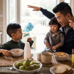 asian father and two sons playing at a table