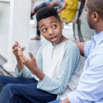 padre afroamericano hablando con su hijo en lugar de ponerlo en tiempo fuera