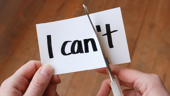 scissors cutting through a paper that reads "I can't"