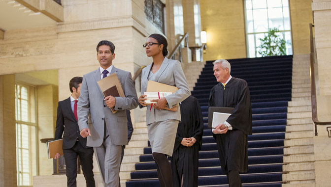 lawyers walking through a court house and the start of the criminal justice system