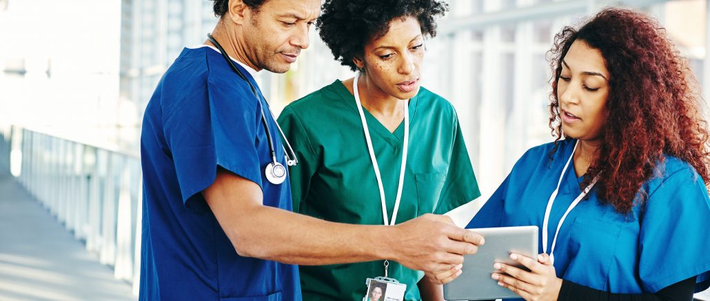 diverse group of nurses looking at a patient chart.
