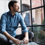 hombre contemplando un máster online por una ventana