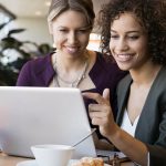 two women looking at a laptop