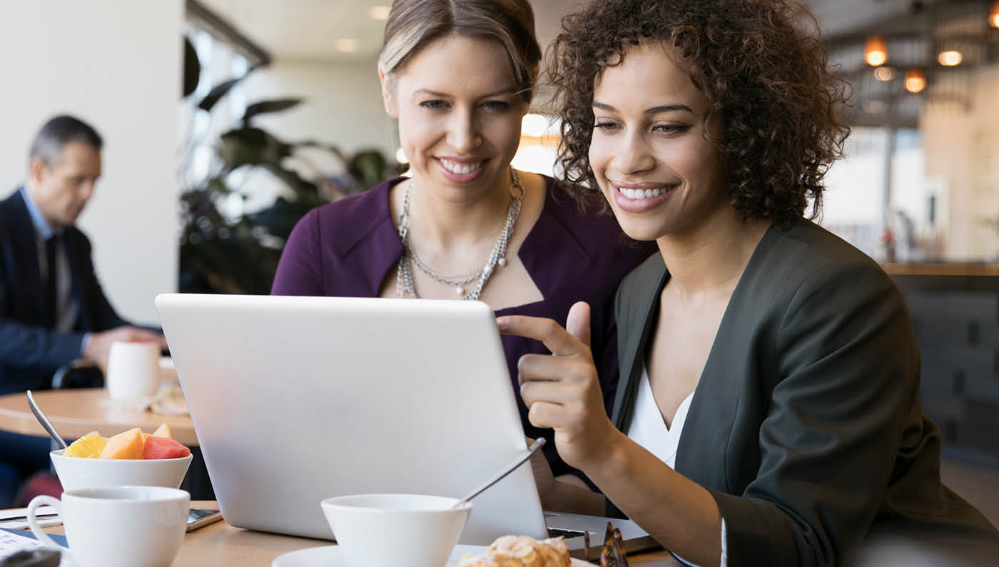 dos mujeres que miran un portátil