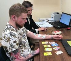 hombre en el escritorio conectado a un cardiograma mientras mira las tarjetas