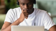 An online student focuses on his laptop while taking on online course