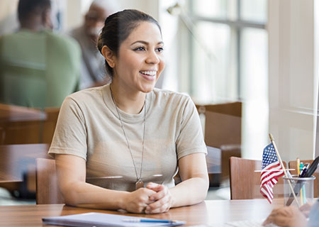 Female Veteran sits at desk