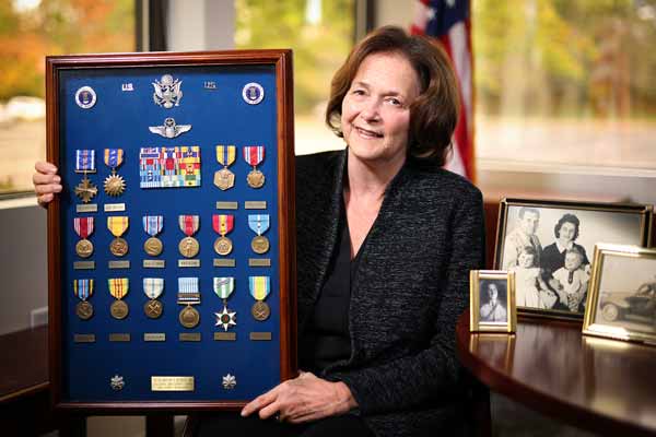 Bryanne Hamil holding a display case of her father's military medals.