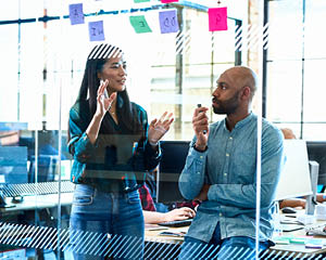 two coworkers discussing a project in an office