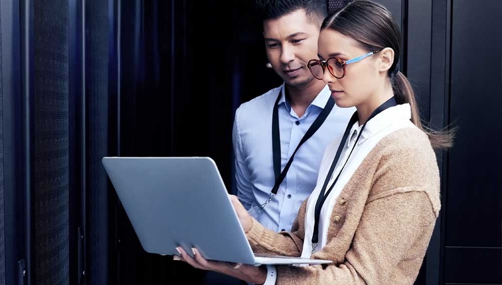 Cybersecurity professionals review data on a laptop