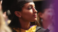 An Excelsior University student in cap and gown at commencement ceremony.