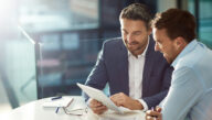 two businessmen reading paperwork