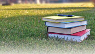 stack of books with pen on top