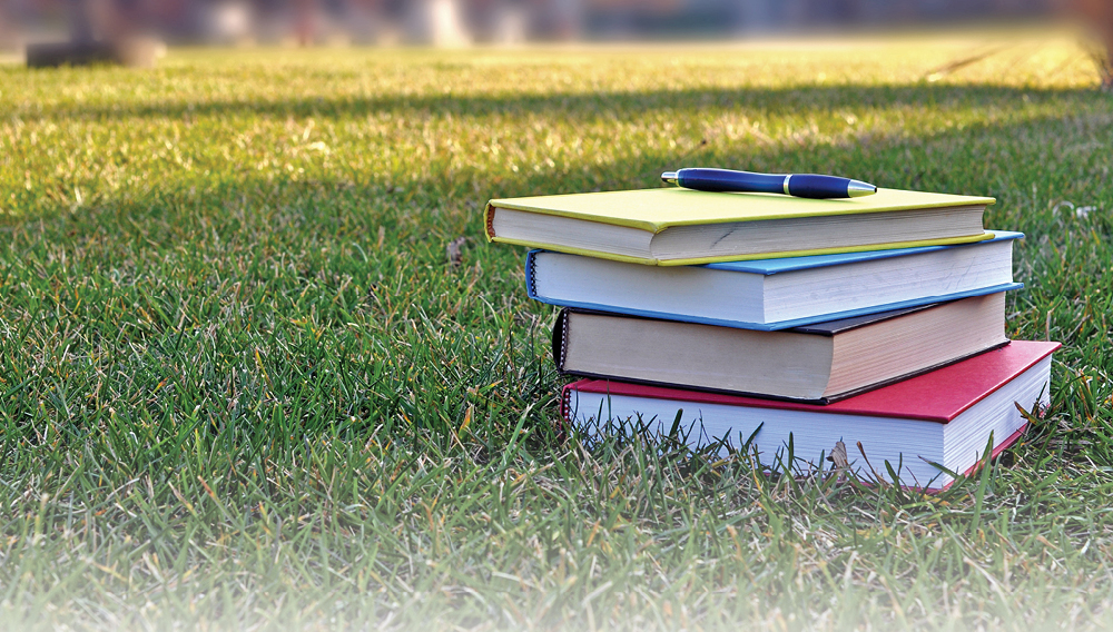 stack of books with pen on top