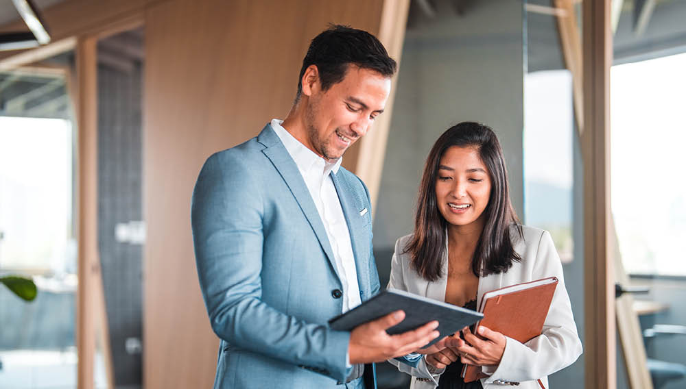 man and woman business professionals looking at tablet