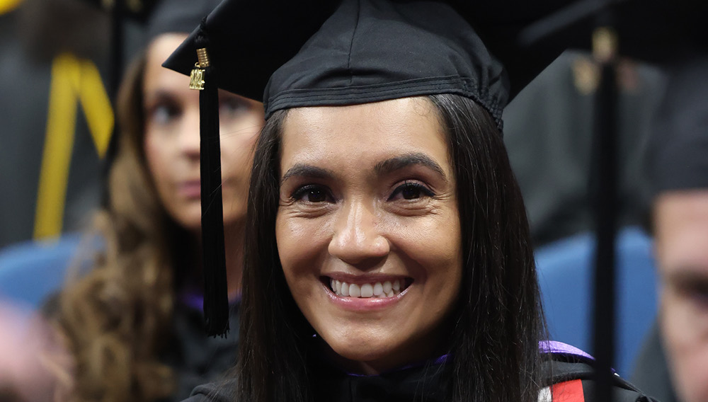 Middle-aged college graduate in cap and gown