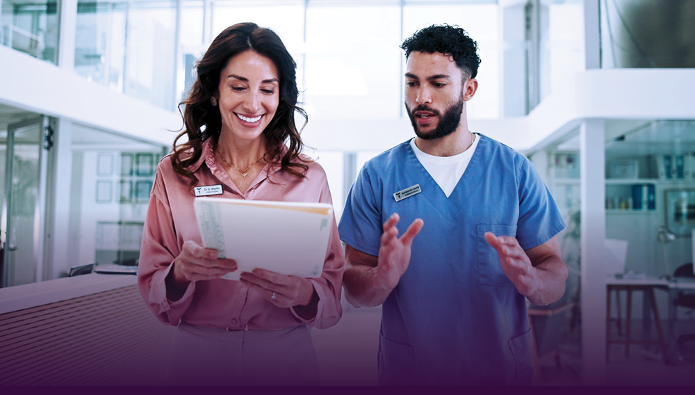 A health administrator looks over a chart with a nurse.