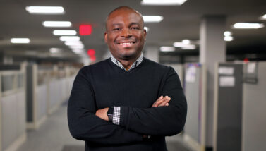 Khamel Abdulai with his arms folded, standing in the hallway.