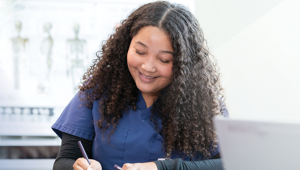 Smiling nurse studying for the NCLEX-RN