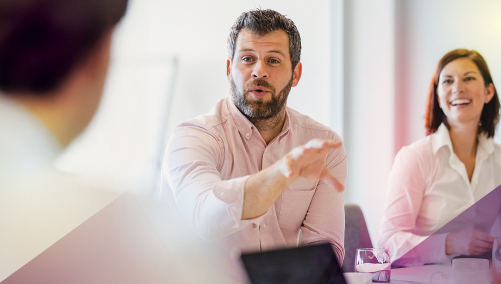 Consultant in rolled-up sleeves making a point in a boardroom