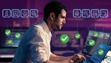 Man intensely working on multiple screens and ticking through a cybersecurity checklist