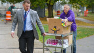 Ryan Meikle, Troy High School assistant principal (left), and Zach Patterson, Excelsior University community engagement group co-chair (right), deliver Snacks for Students donations to Troy High School.
