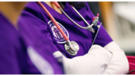 A nurse with stethoscope and Excelsior University scrubs in a clinical practice setting.