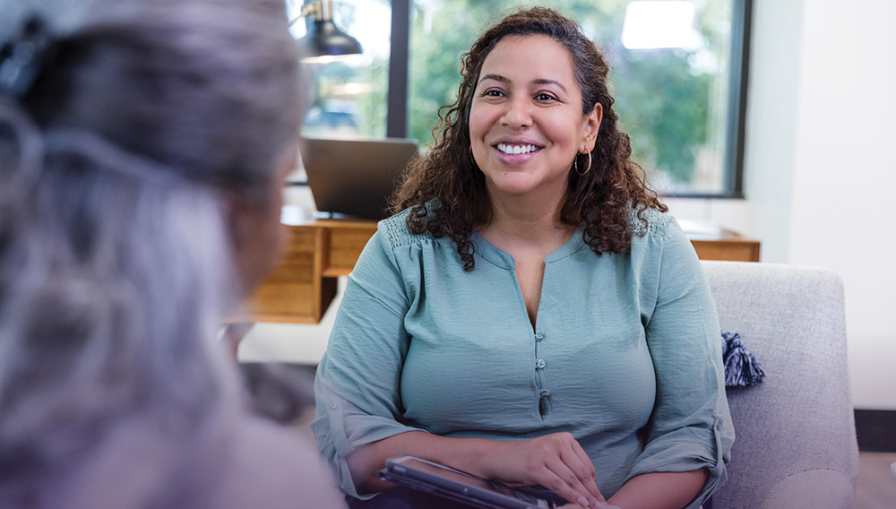 Smiling patient sits in a therapist’s office