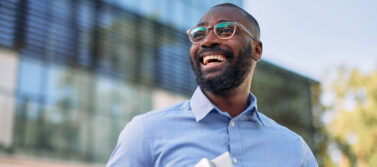 smiling man outside an office building