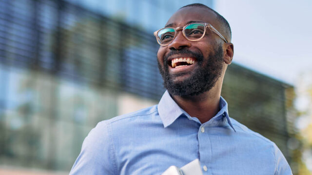 smiling man outside an office building