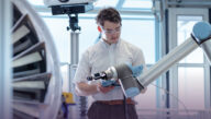Mechanical engineering technologist working on a robotic arm in an aerospace technology lab