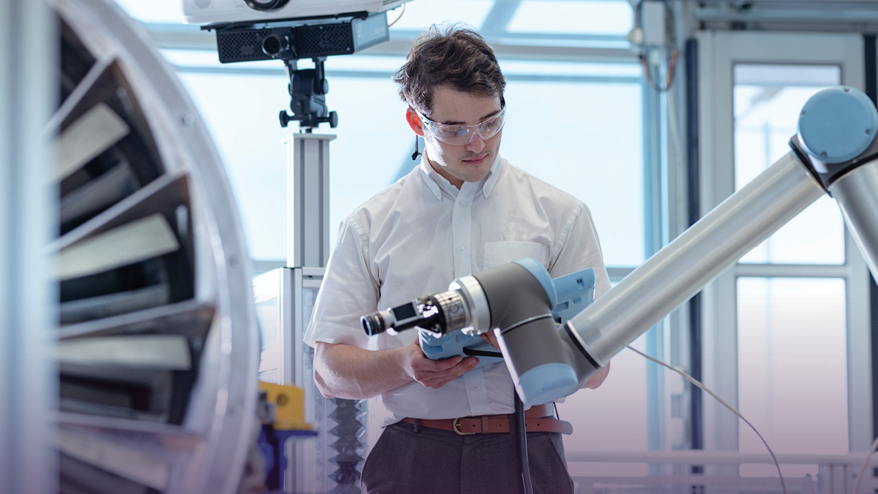 Mechanical engineering technologist working on a robotic arm in an aerospace technology lab