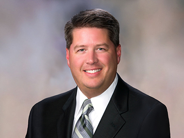 Headshot of Jake Smith in a suit and tie.